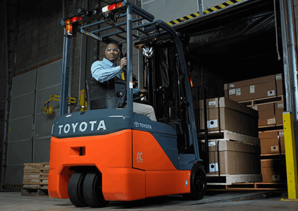 3 wheel Toyota forklift moving products out of a trailer